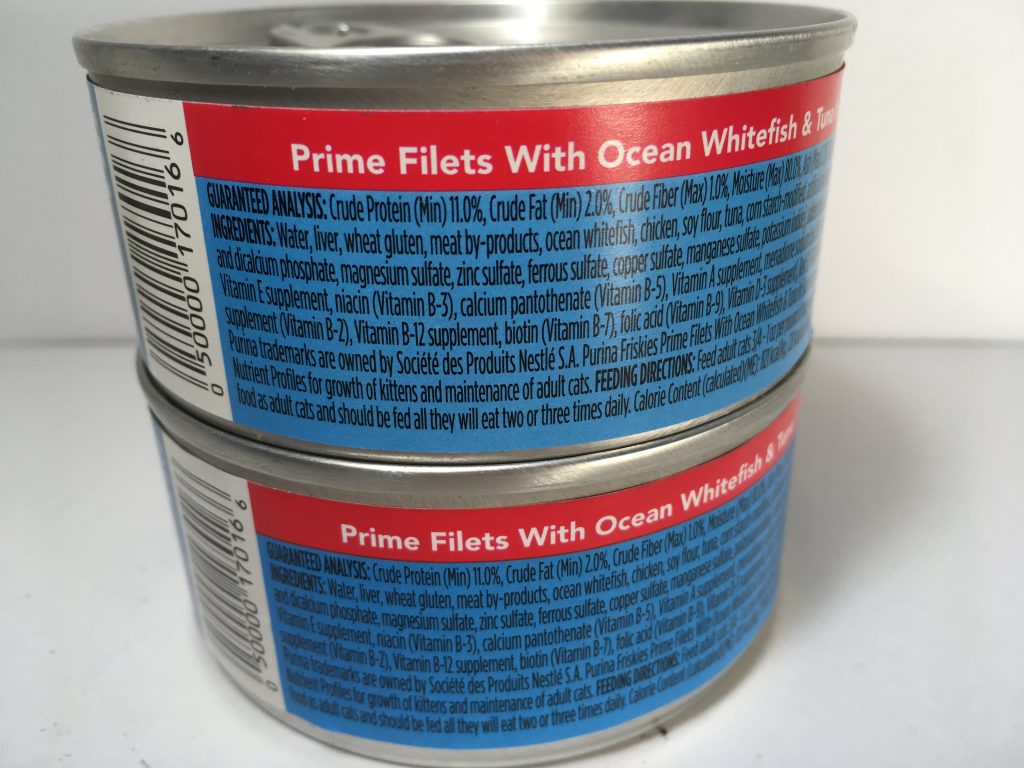 The back of two cans of delicious cat food stacked together, friskies prime filets with Ocean Whitefish and Tuna in Sauce