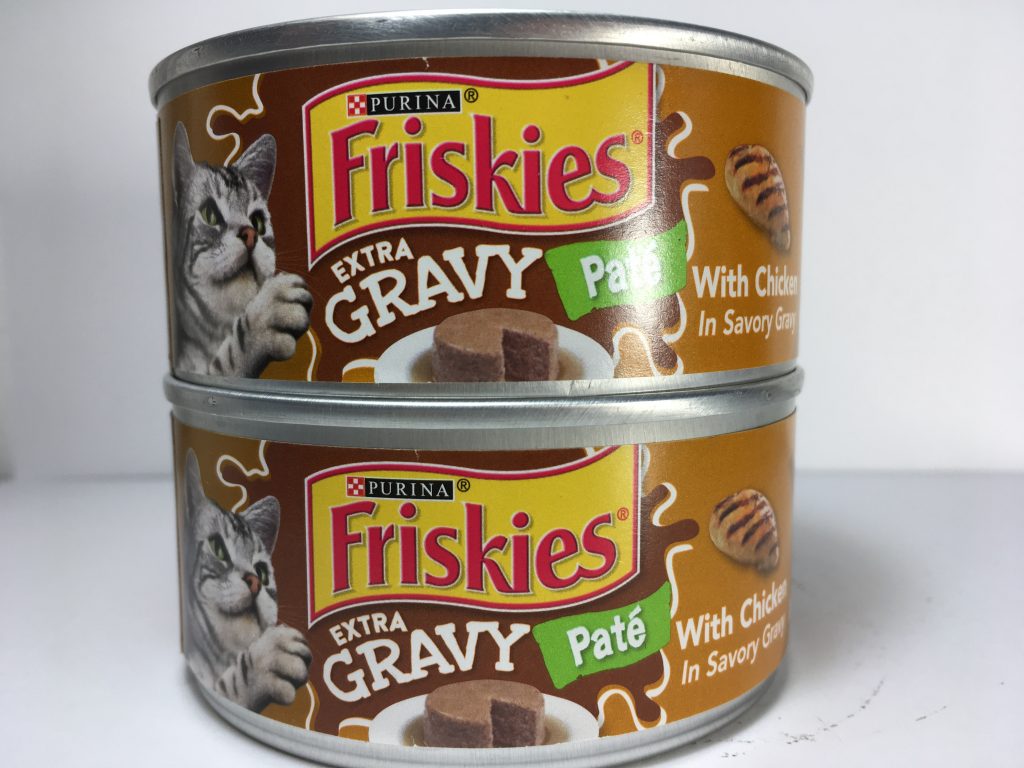 The front of two cans of delicious cat food stacked together, friskies, Pate, Extra Gravy, With Chicken in Savory Gravy