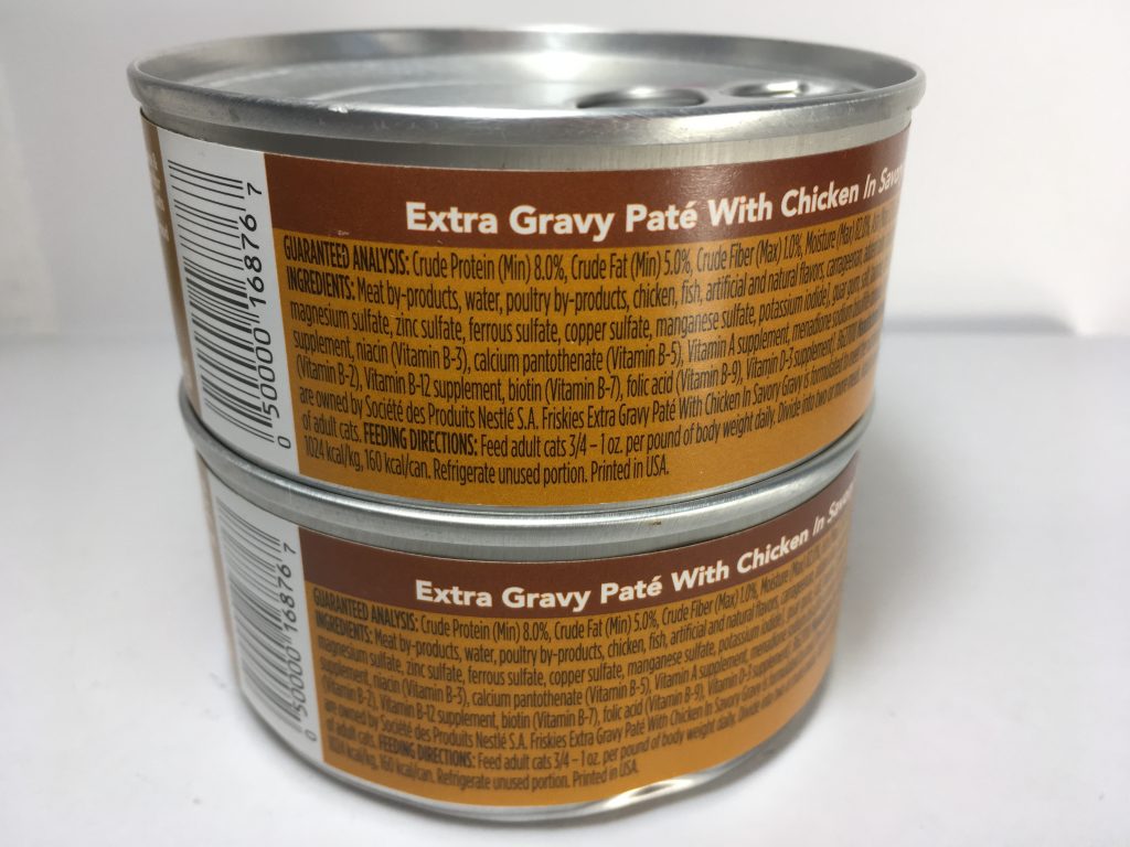 The back of two cans of delicious cat food stacked together, friskies, Pate, Extra Gravy, With Chicken in Savory Gravy